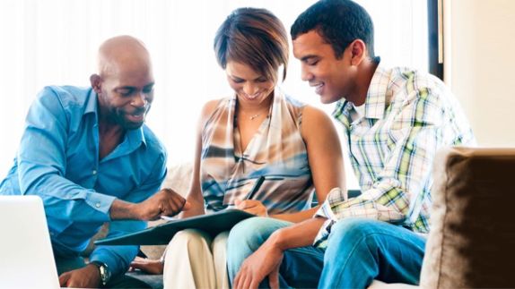 Satisfied family filling out claims form together.