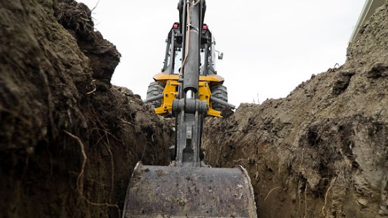 Yellow digger excavating the ground.