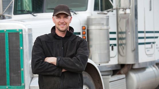 Truck driver in front of truck