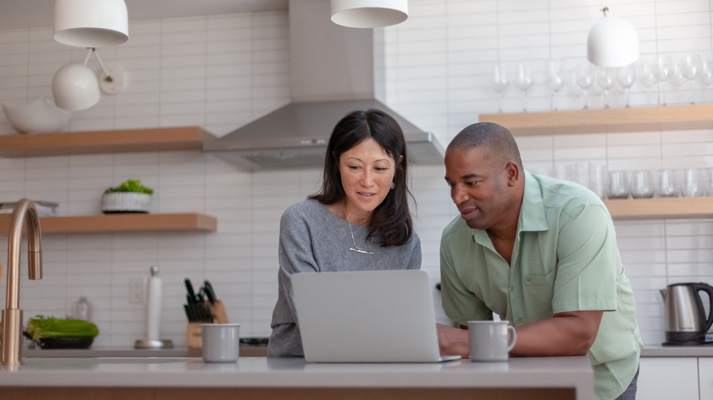 Couple looking at a laptop screen together.
