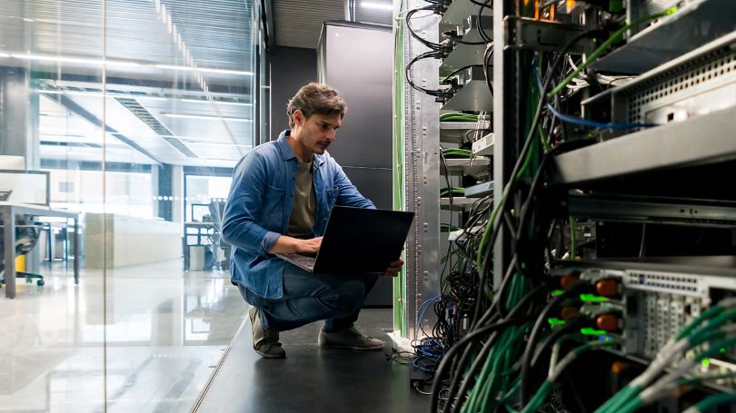 Technicien en informatique réparant un serveur réseau au bureau