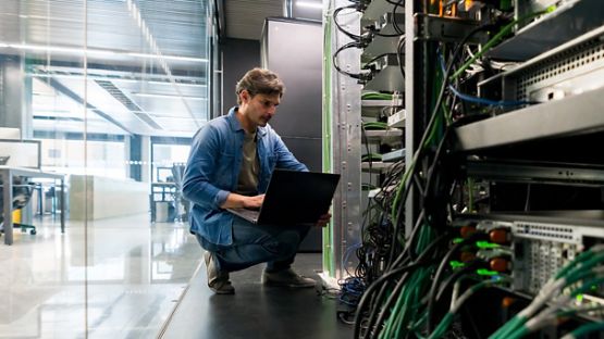 Technicien en informatique réparant un serveur réseau au bureau