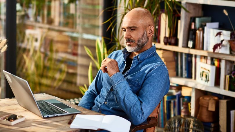 Man sitting in home office and looking at laptop screen