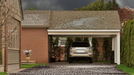 A car parks under a carport, protected from a hailstorm.