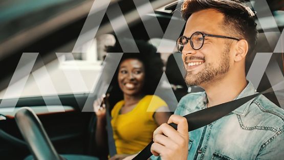 A happy couple in the front seat of a car, enjoying life’s journeys while the driver still maintains focus and attention on good driving