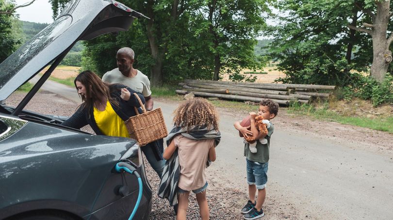 A young family on a road trip charging their EV
