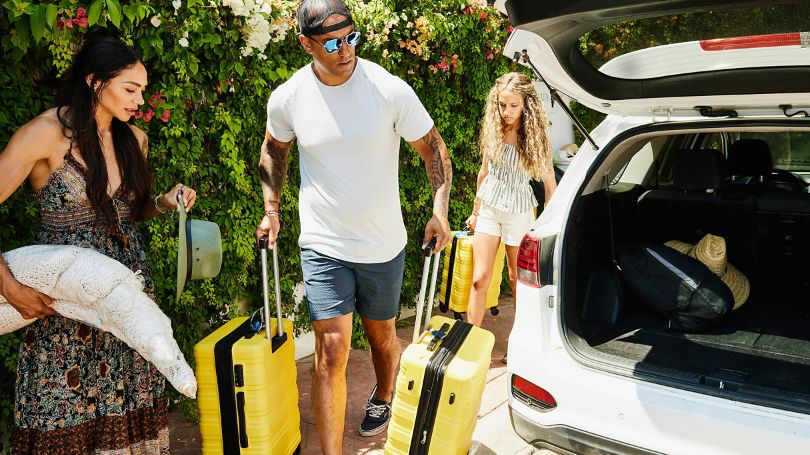 Family loading luggage into a rental vehicle