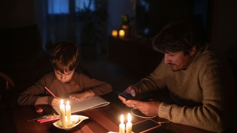 A family sheltering in place on the first level of the home in a candle-lit room