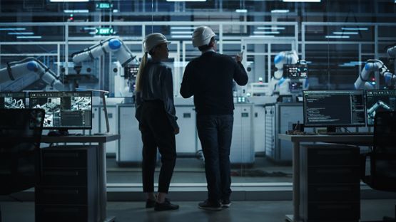 Des ingénieurs discutent dans une usine robotisée