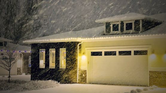 Maison illuminée pendant une nuit de neige