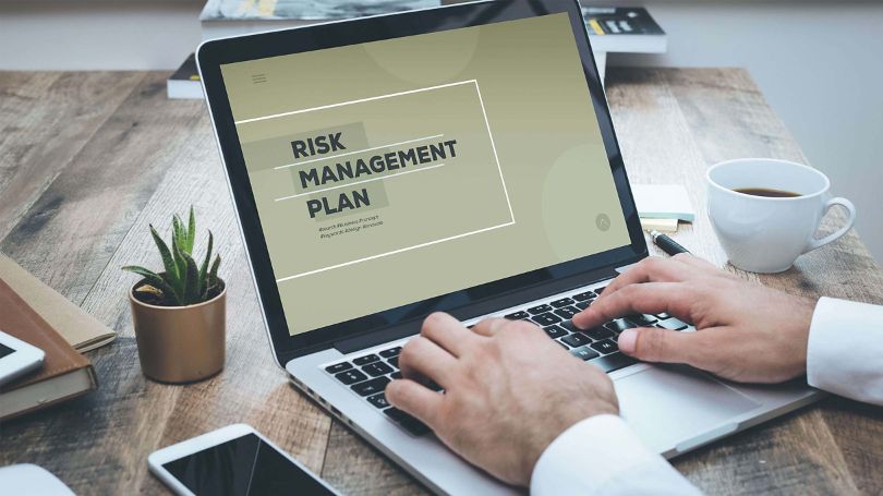 Man at laptop developing risk management plan