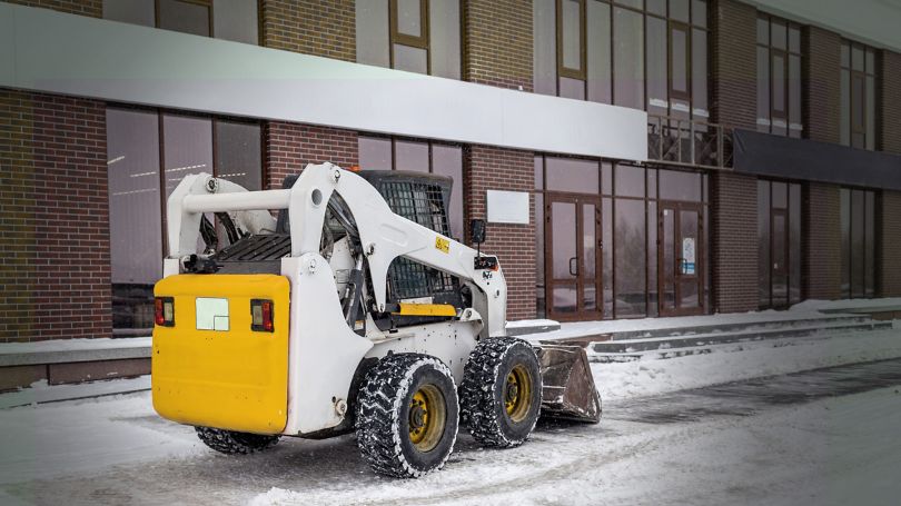 Snow removal contractor clearing parking lots and walkways