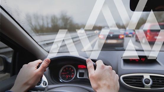 A close-up image of a driver, with the seatbelt on, and with hands firmly on the wheel in the correct driving position to ensure good driving