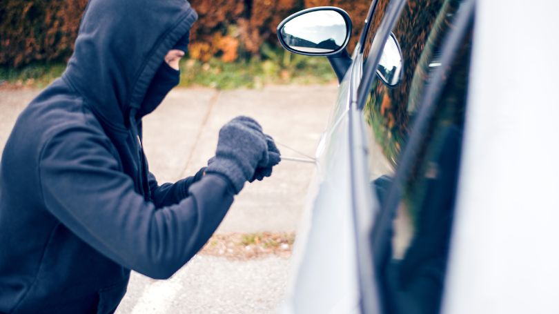 Un voleur tente de s'introduire dans une voiture.