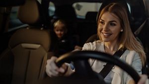 Une femme conduisant une voiture avec un enfant sur la banquette arrière; visages floutés pour respecter la vie privée.