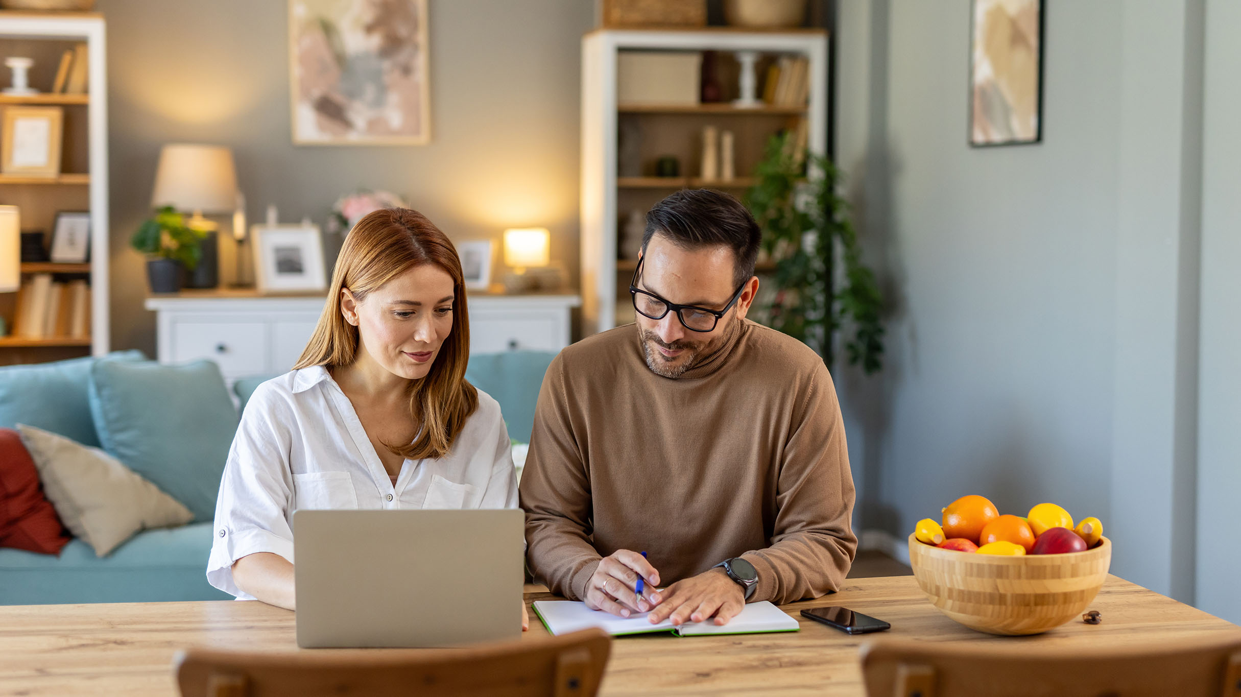 Couple reviewing information together on a laptop at home.
