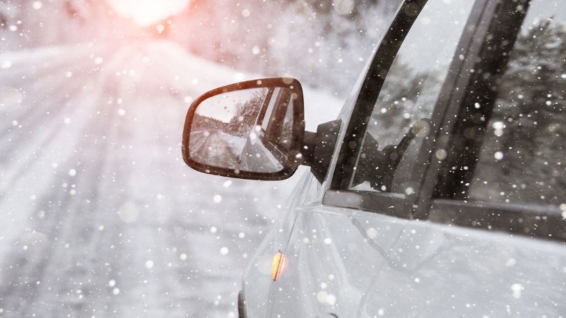 Close up of car driving in the winter, snowy