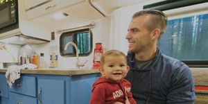 Father and son sitting in an RV enjoying themselves.