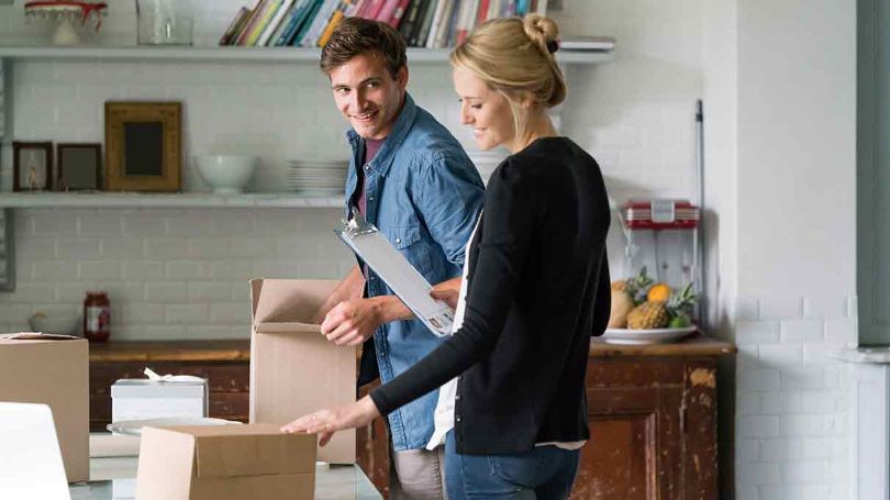 Happy couple packing boxes in their home.