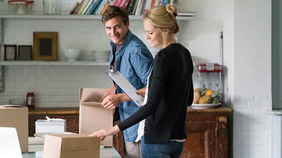 Couple heureux en train de faire des boîtes dans leur maison