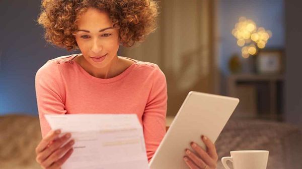 Woman reviewing expensive energy bills looking to save money.