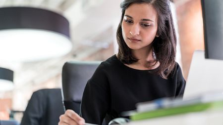 Préposée à l'indemnisation travaillant sur un ordinateur.