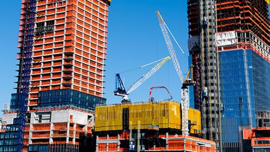 Chantier de gratte-ciels sur fond de ciel bleu.