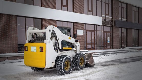 Entrepreneur en déneigement déneigeant le stationnement et les passages