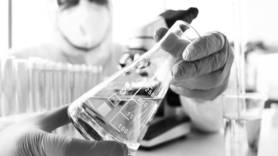 Close up of a person holding a science beaker
