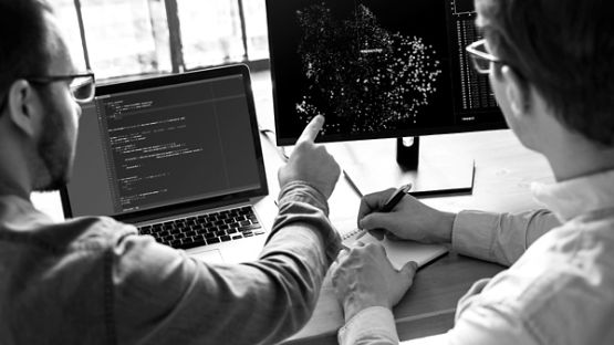 Two men reviewing data on a computer