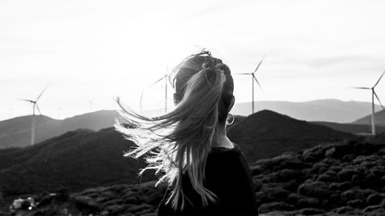 Woman looking at wind turbines outside