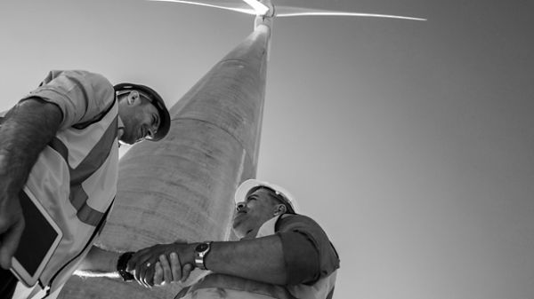 Two men wearing hard hats and shaking hands