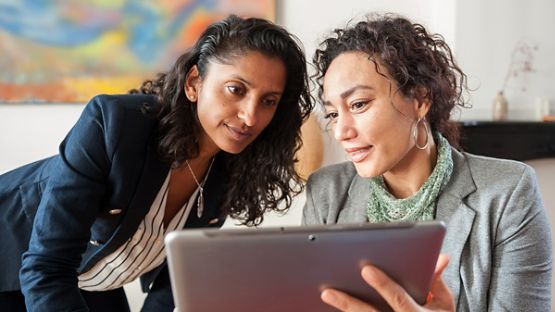 Two businesswomen looking at a tablet