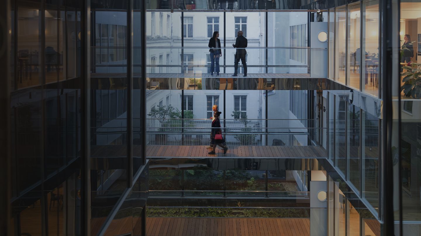 Collègues traversant une passerelle surélevée d’un immeuble à bureaux