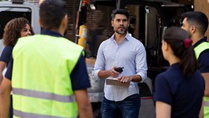 Manager talking to group of warehouse workers