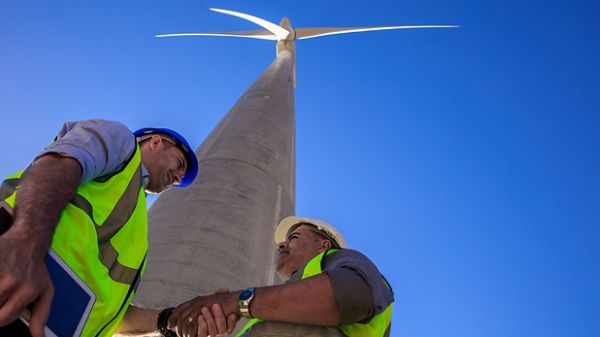 Two men wearing hard hats and shaking hands