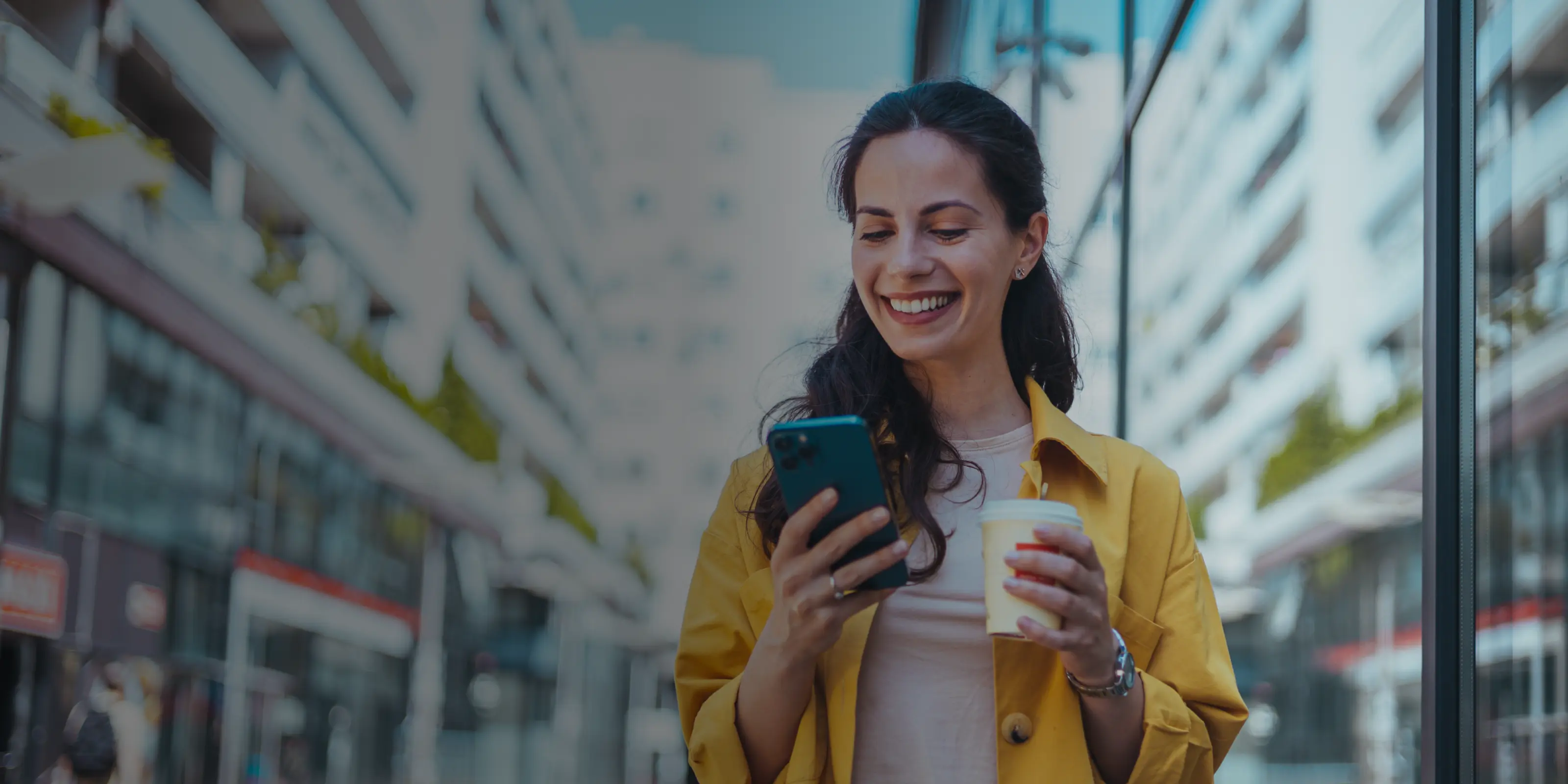 Woman holding coffee while looking at her phone