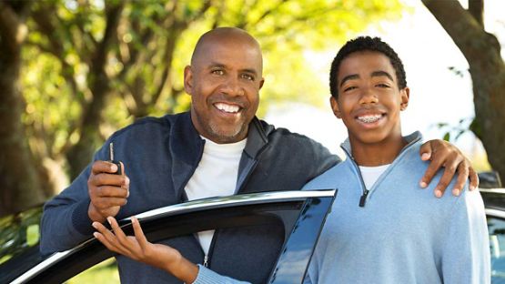 Son receiving keys for his first car from his dad.