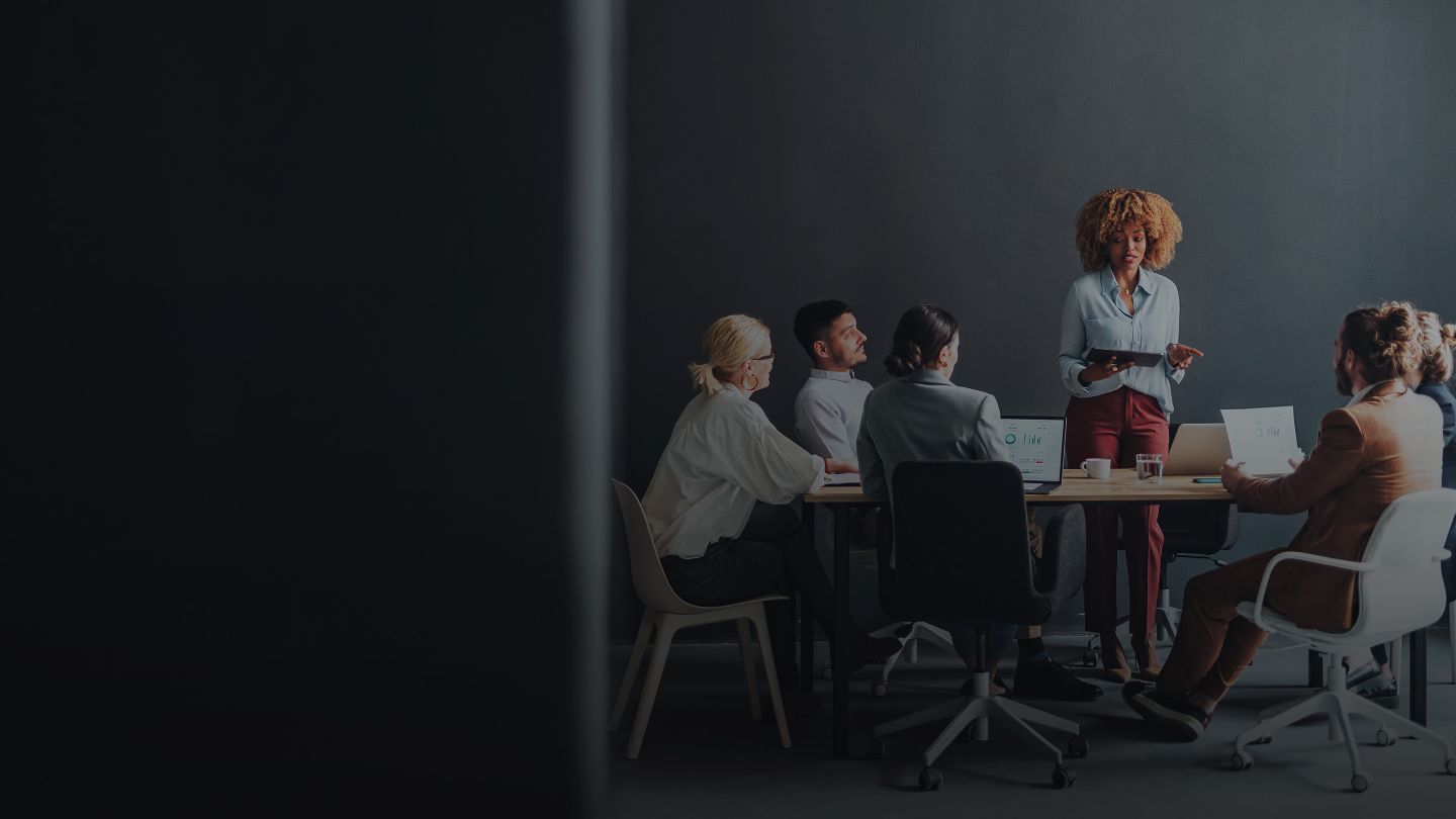 Employees in office meeting room listening to a presentation