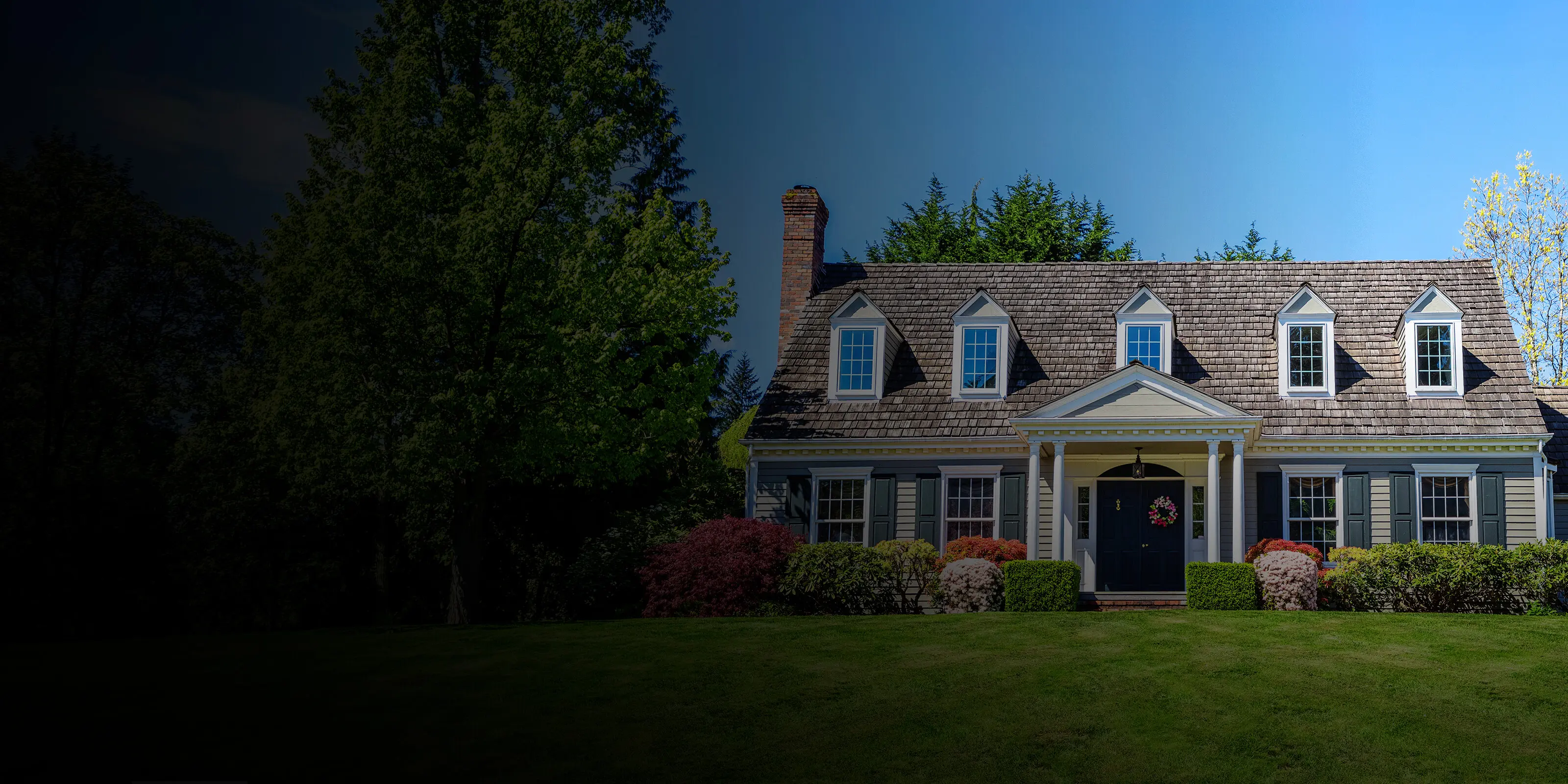 Detached house with a large front lawn and landscaped yard.