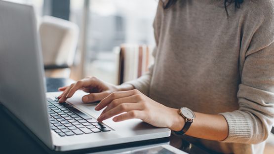 Femme accédant au matériel de formation des courtiers sur un ordinateur portable