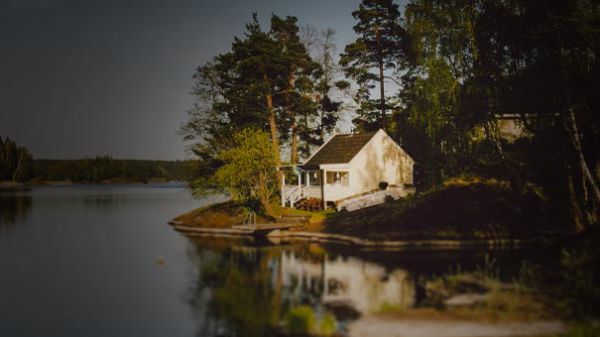 Landscape image of a cottage on a lake 
