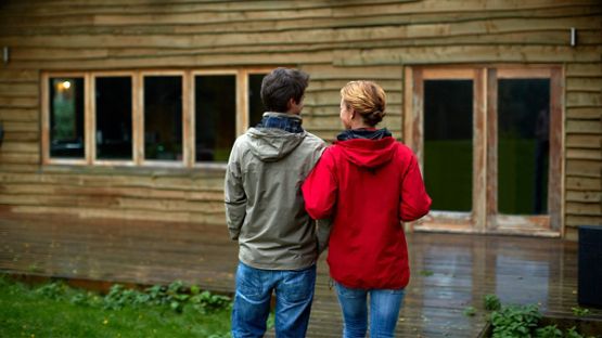 Couple standing outside looking at their cottage