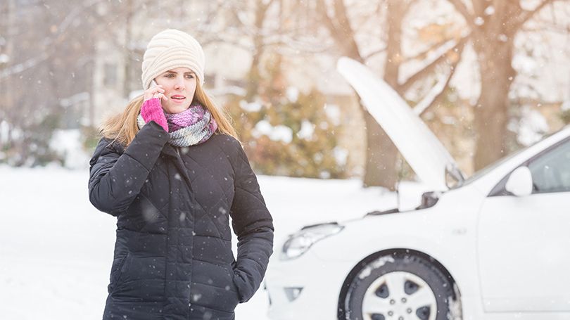 Person on the phone with roadside assistance to help with car defect