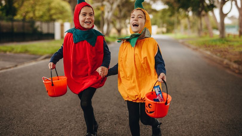 Children dressed in costumes going trick or treating on Halloween