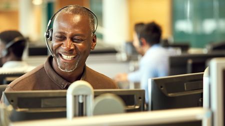 Happy male insurance representative at a call centre. 