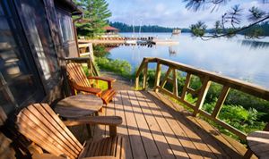 Muskoka chairs on a porch overlooking the lake.