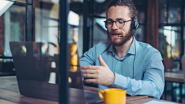 Man wearing headset while sitting in front of laptop