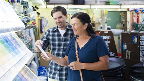 Paint store owner showing woman paint colour samples