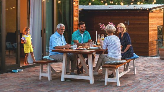 Cheerful family enjoying a meal on a cottage patio